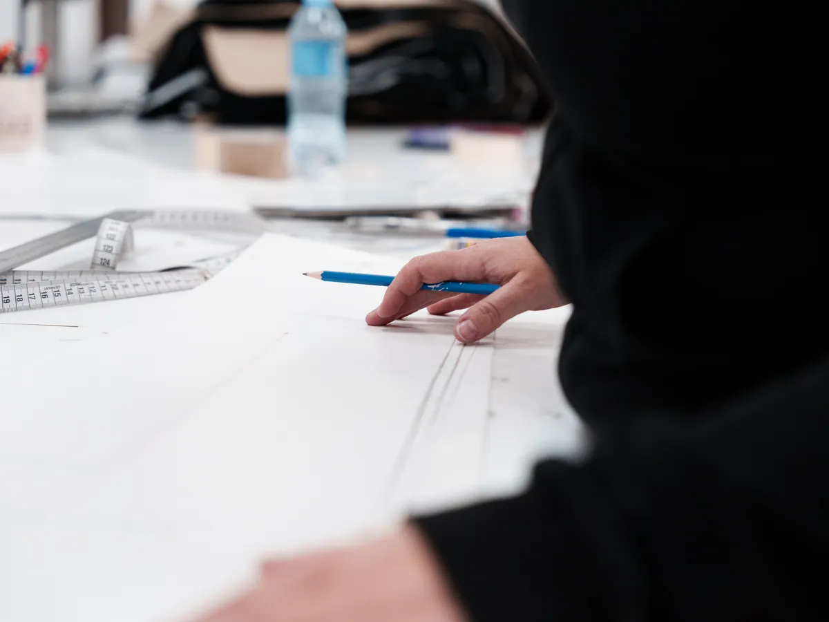 A technical drawing and a tape measure on the product development table
